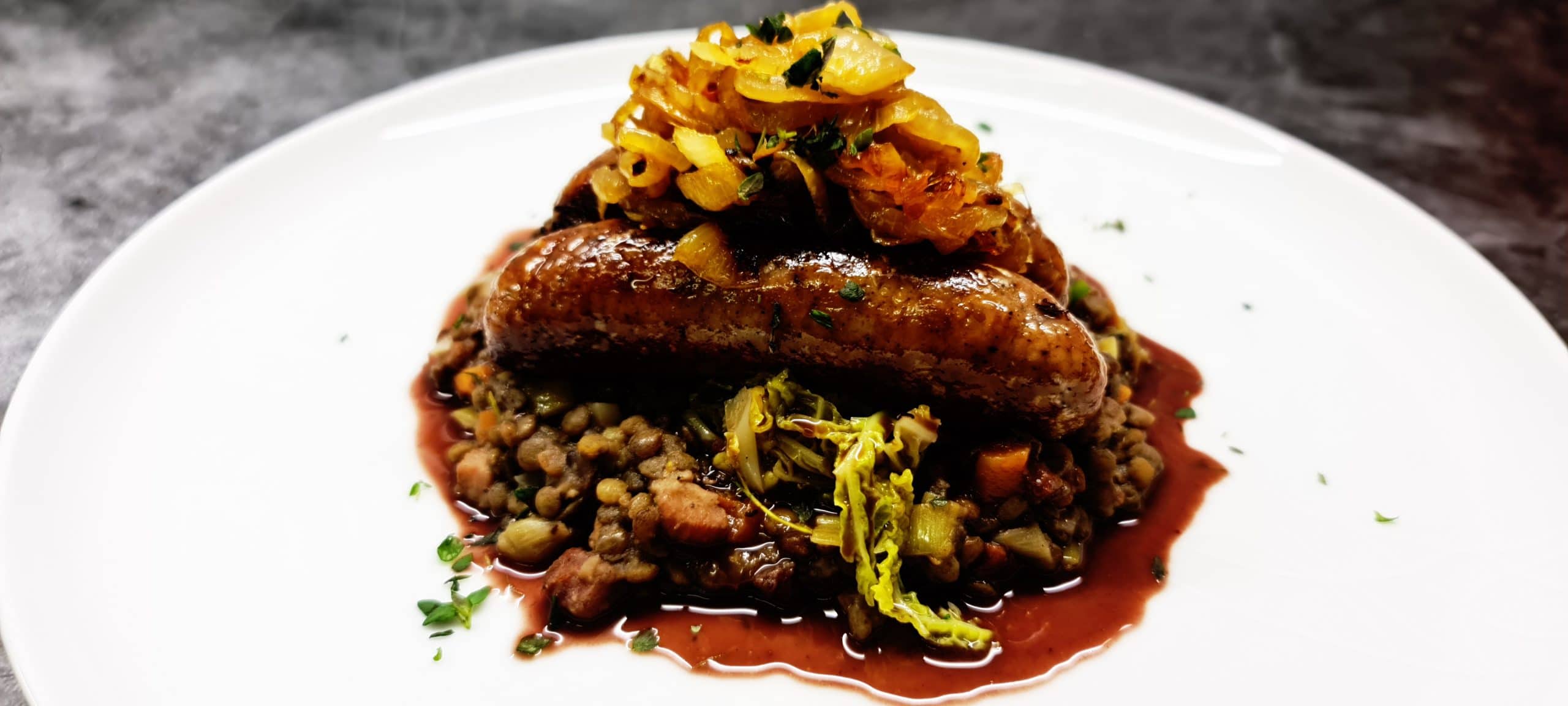 You are currently viewing Butchers Sausages with Braised Puy Lentils, Buttered Cabbage and Caramelised Onions